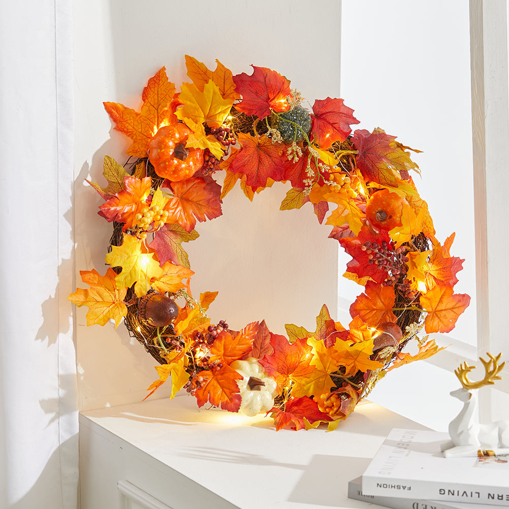 The branch ring autumn wreath lit up beside a small deer figure on a white shelf
