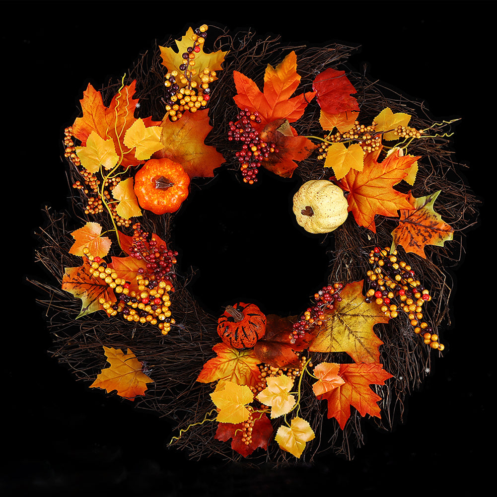 Autumn wreath with orange pumpkins, berries and maple leaves on a black background