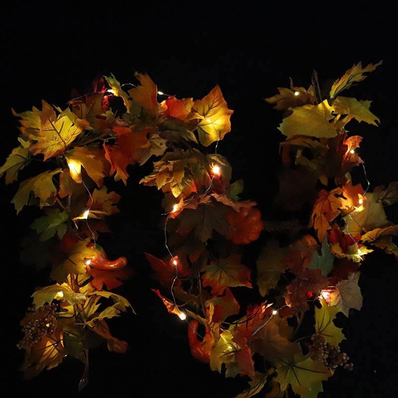 Maple leaf garland with its warm LED lights glowing against a dark background