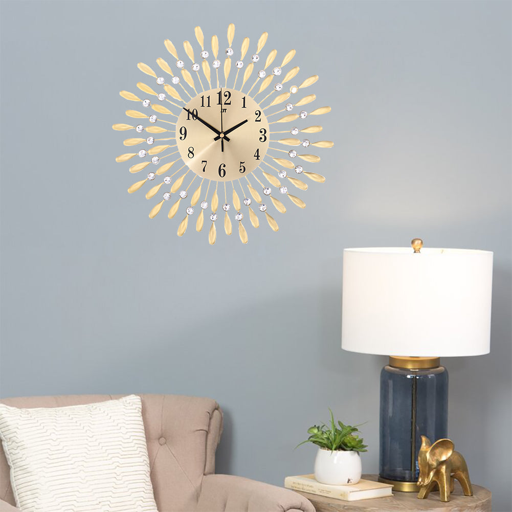 The gold sunburst wall clock above a sofa on a grey wall