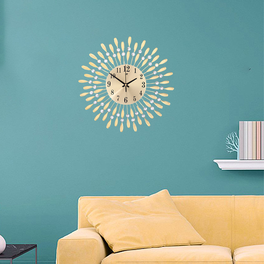 Round gold wall clock with drop-shaped metal rays and crystal beads on a teal living room wall