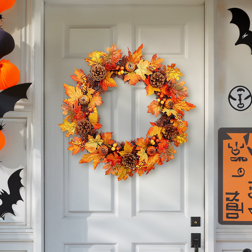 The orange autumn wreath on a white front door beside Halloween decorations