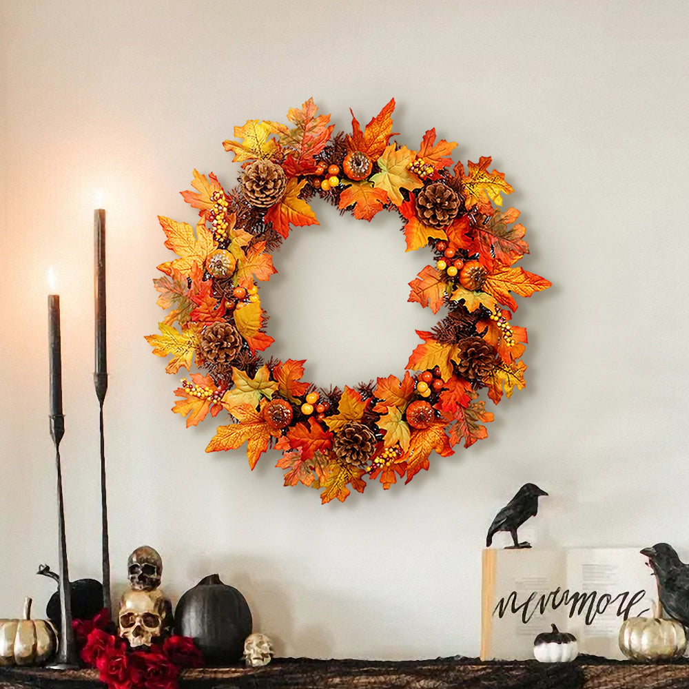 The orange autumn wreath on a wall above a shelf with candles and Halloween ornaments