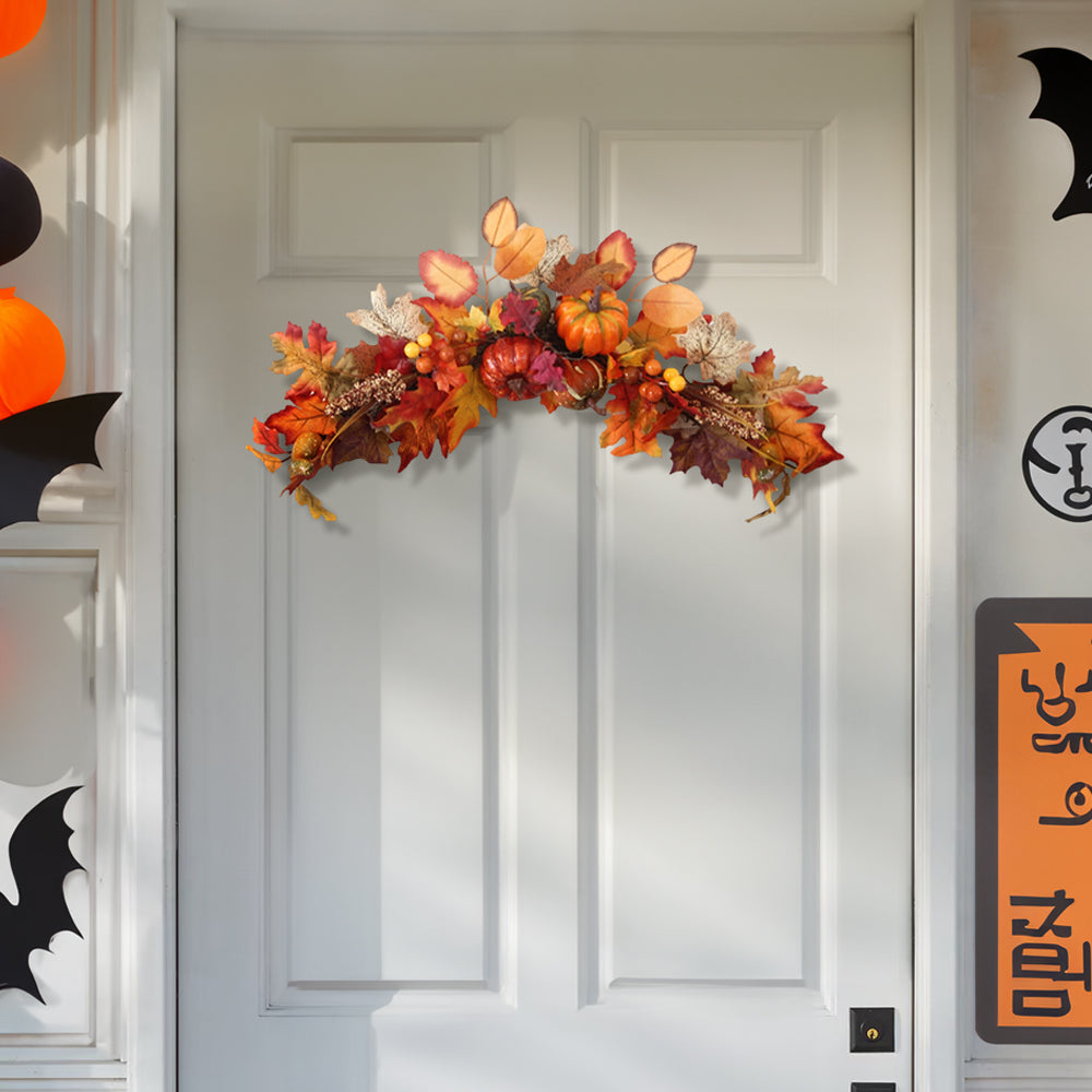 The autumn swag above a white front door beside Halloween decorations