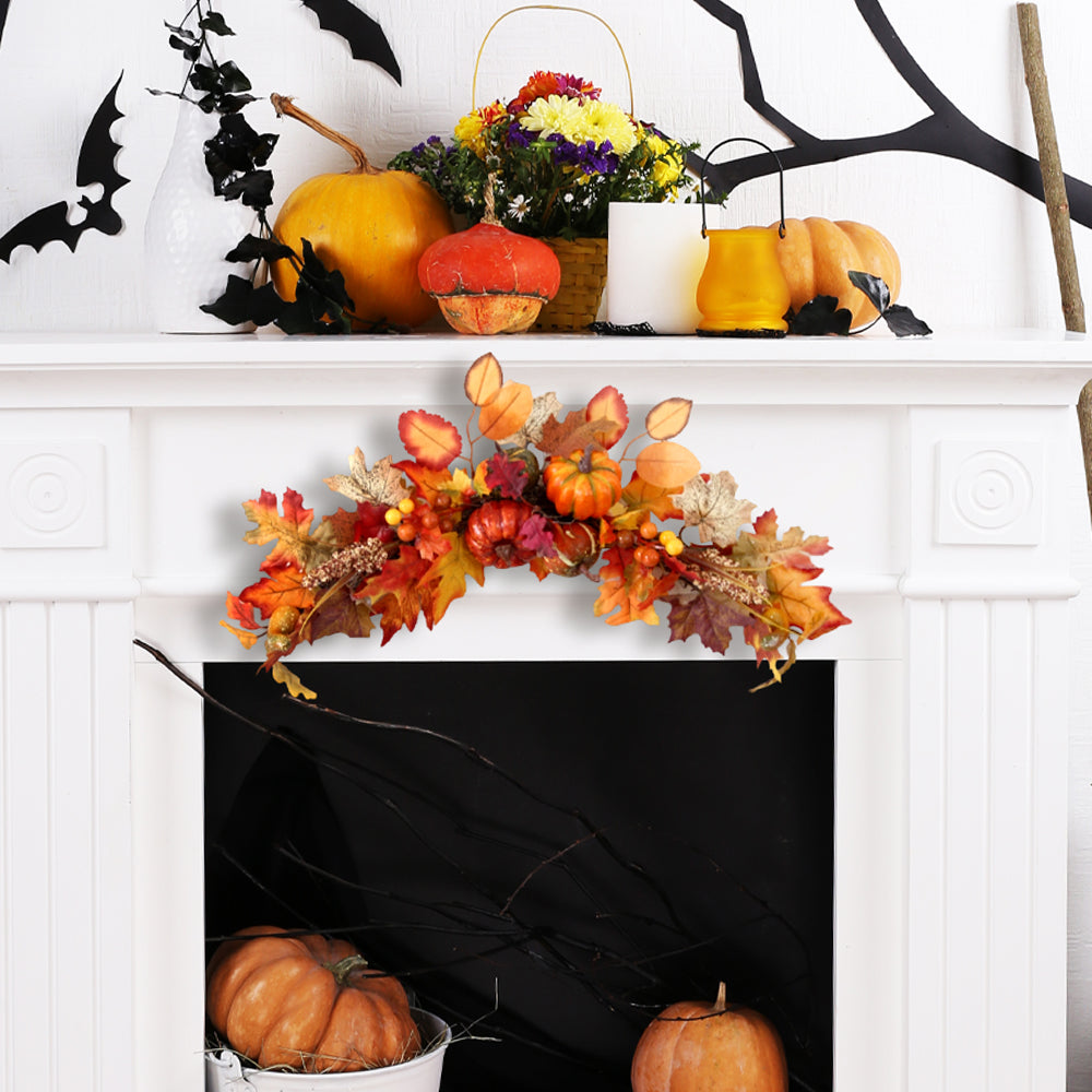 The autumn swag across the front of a white fireplace with pumpkins below