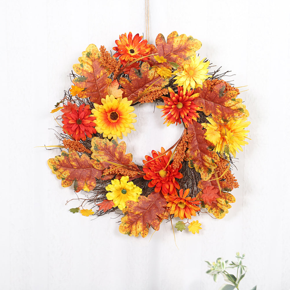 Autumn wreath of orange and yellow daisies, maple leaves and sorghum on white