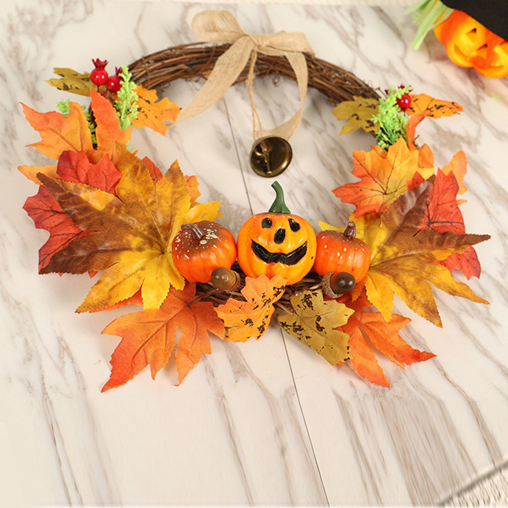 Close-up of the harvest wreath's carved-face pumpkin among orange maple leaves