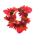 Artificial wreath of red and orange maple leaves with small dark red pumpkins and berries on a white background
