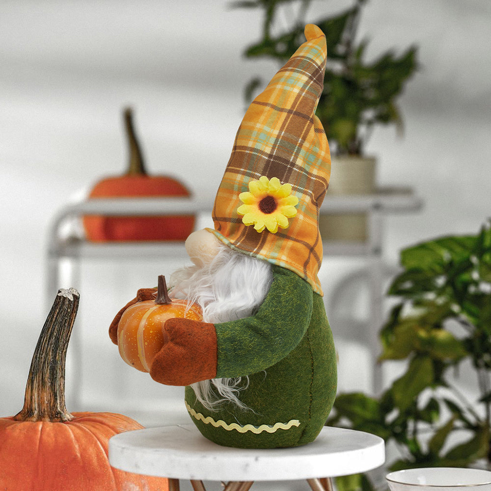 Side view of the plaid-hatted gnome holding a pumpkin on a round white side table