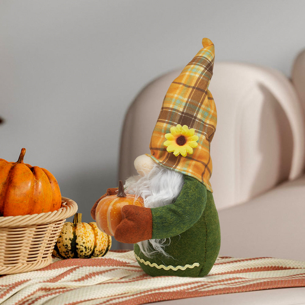 Plaid-hatted autumn gnome with a pumpkin on a striped cloth beside a basket of pumpkins