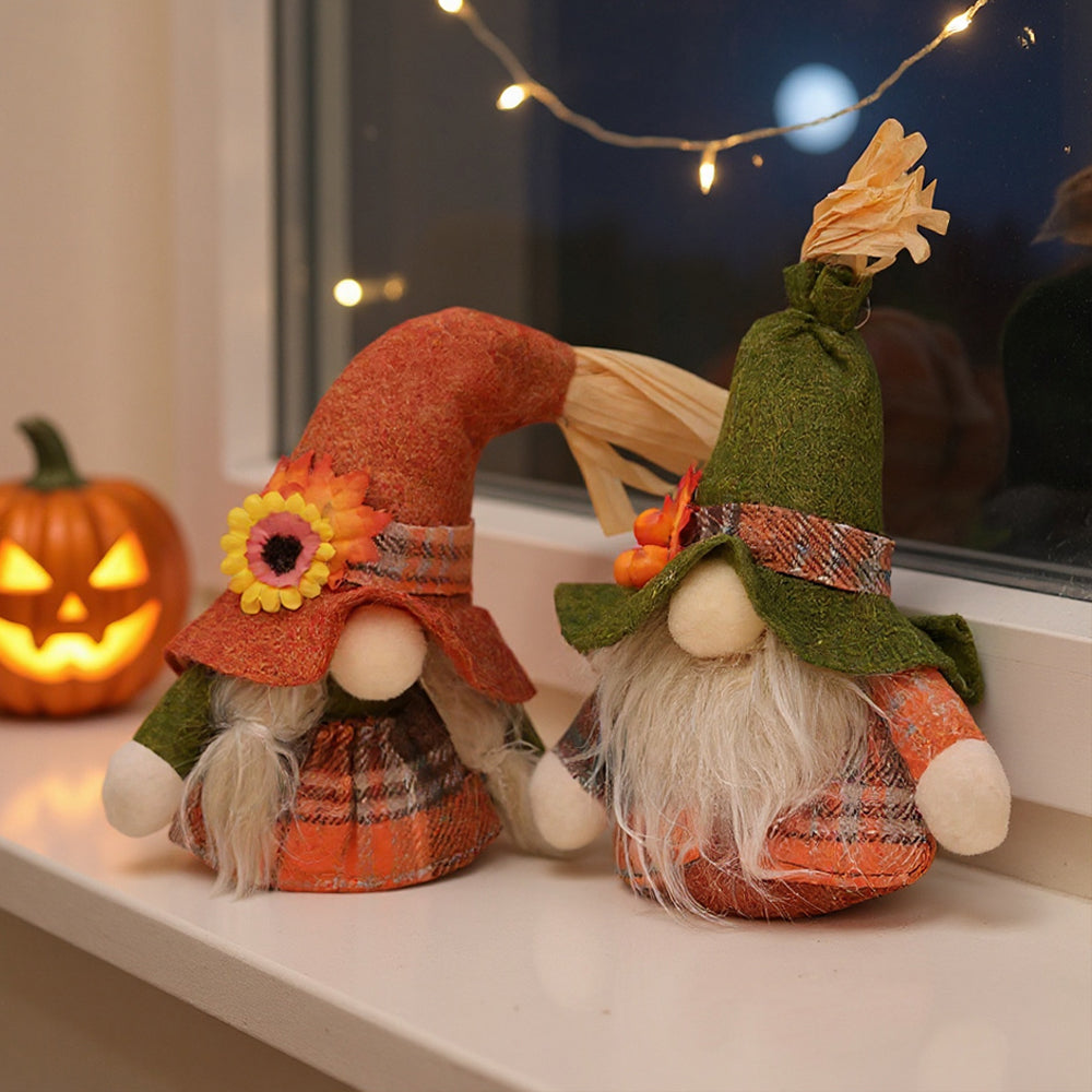 Two autumn gnomes, one in an orange hat with a sunflower and one in a green hat, on a white windowsill