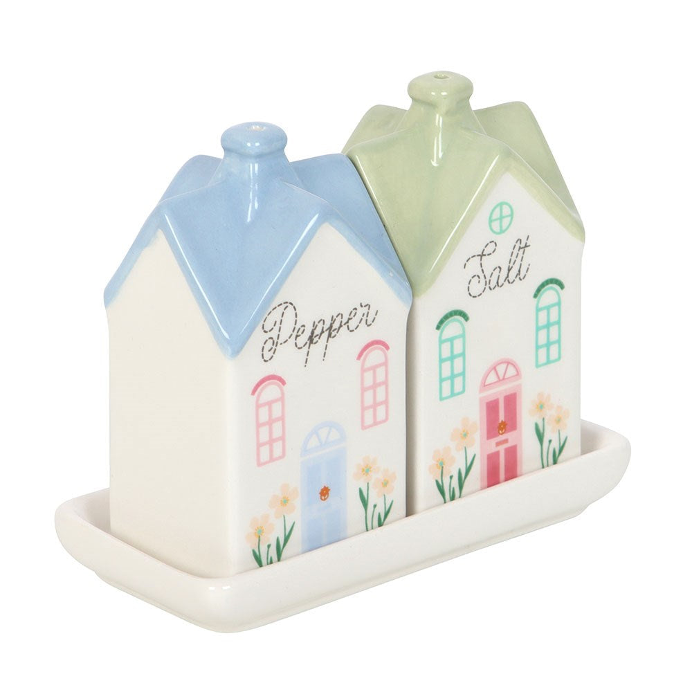 Three-quarter view of the house-shaped salt and pepper shakers with painted windows and flowers