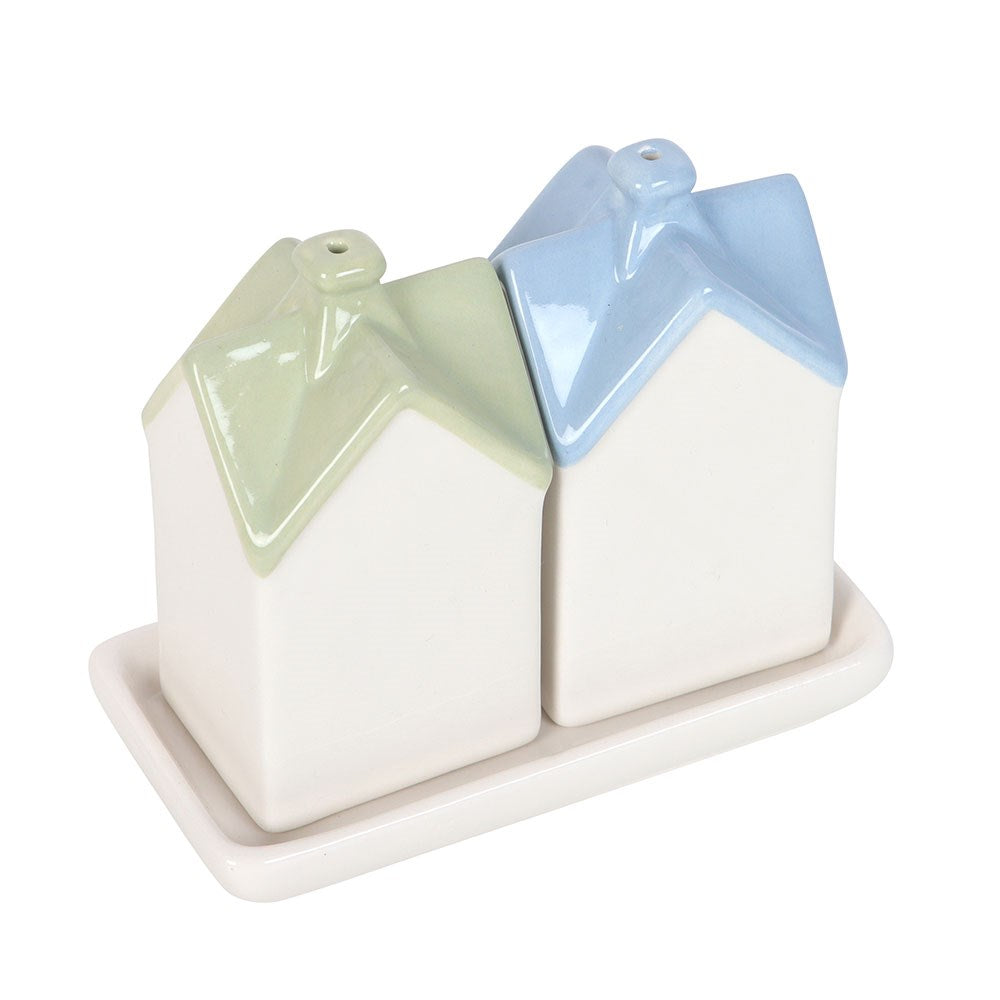 Back of the two house shakers on their tray, plain white walls and pastel roofs