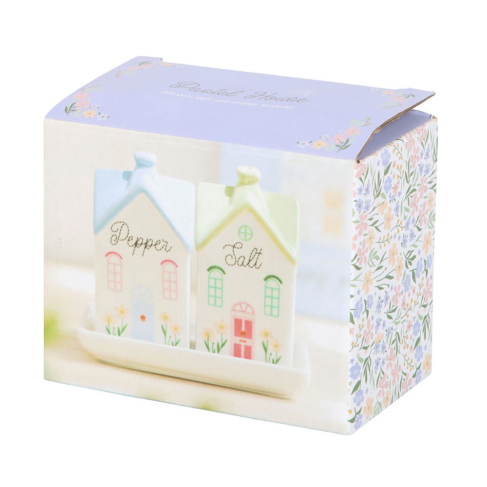 Salt and pepper house shakers in front of their floral gift box