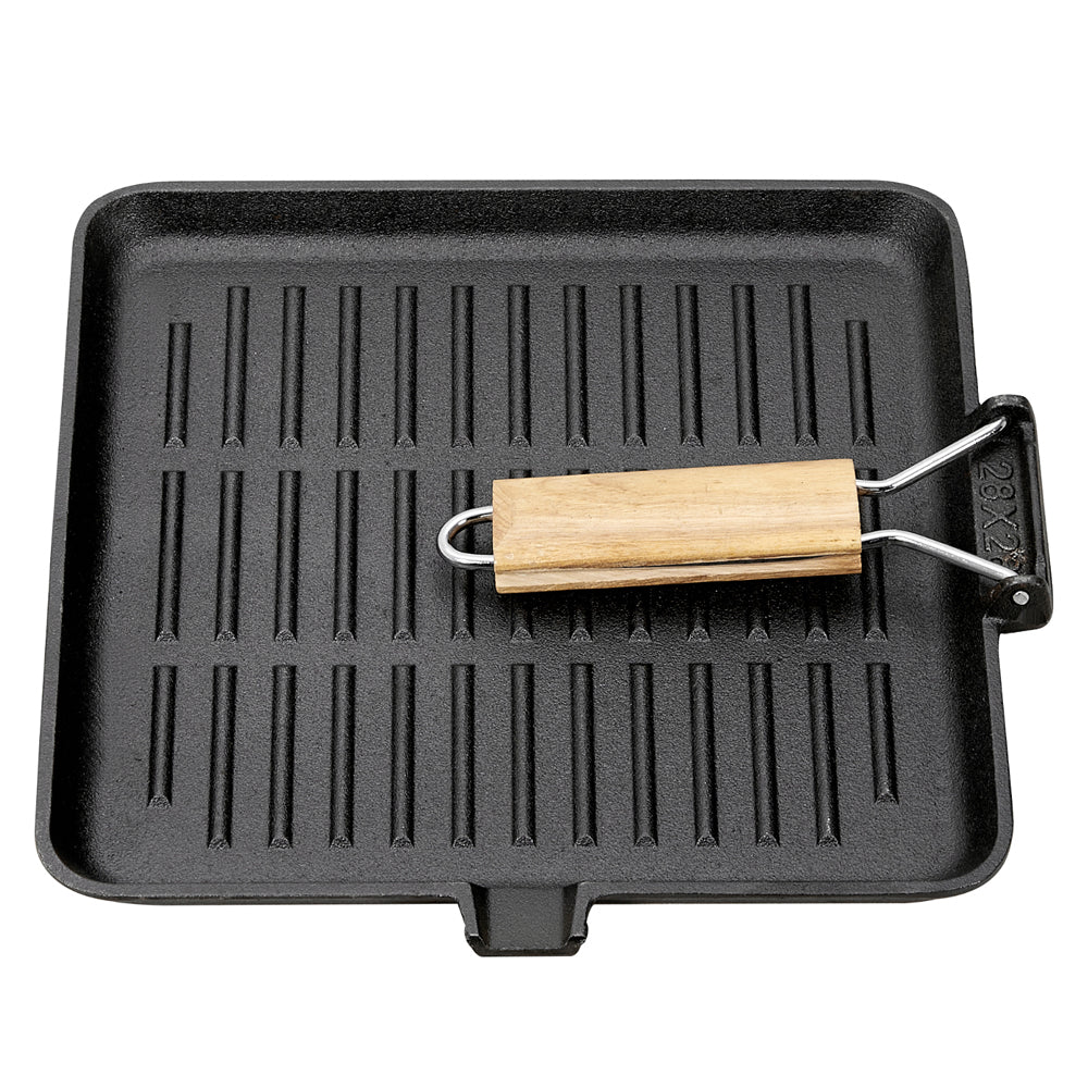 The grill pan on white with its wooden handle folded over the ribbed surface