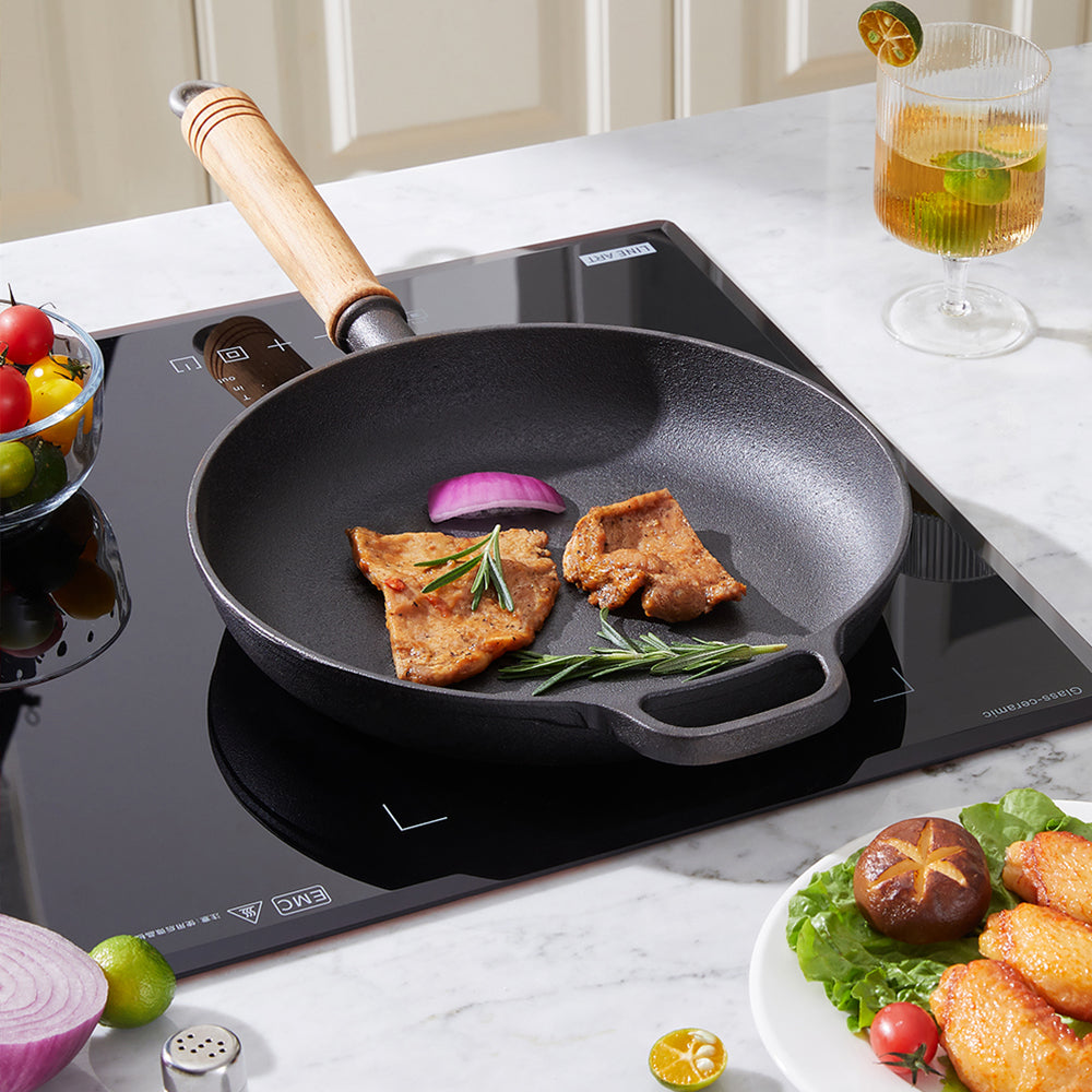 Cast iron skillet with cutlets and red onion on a black induction hob