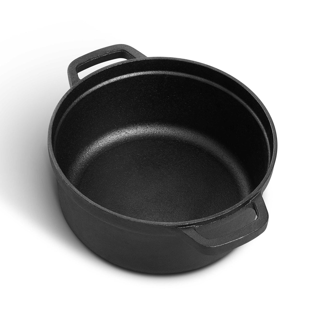 Empty black cast iron Dutch oven without its lid on a white background