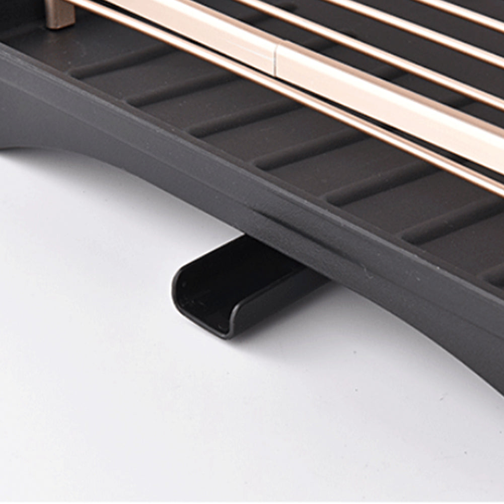 Close-up of the black ribbed drip tray and its short spout