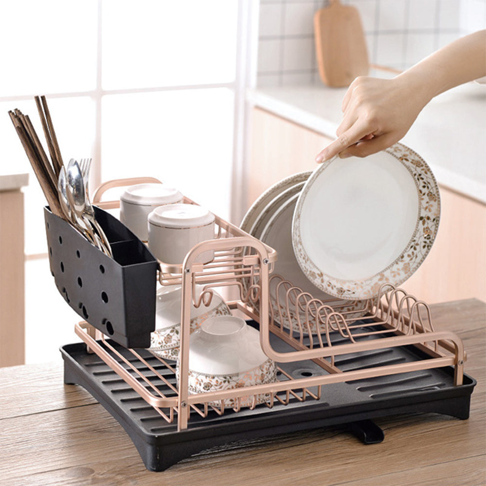 Hand placing a patterned plate into the dish rack, chopsticks in the black holder