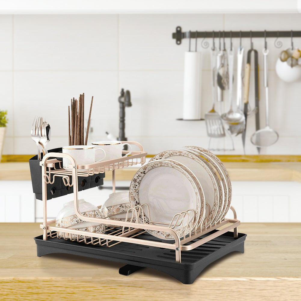 Filled rose gold dish rack on a wooden worktop in front of a utensil rail