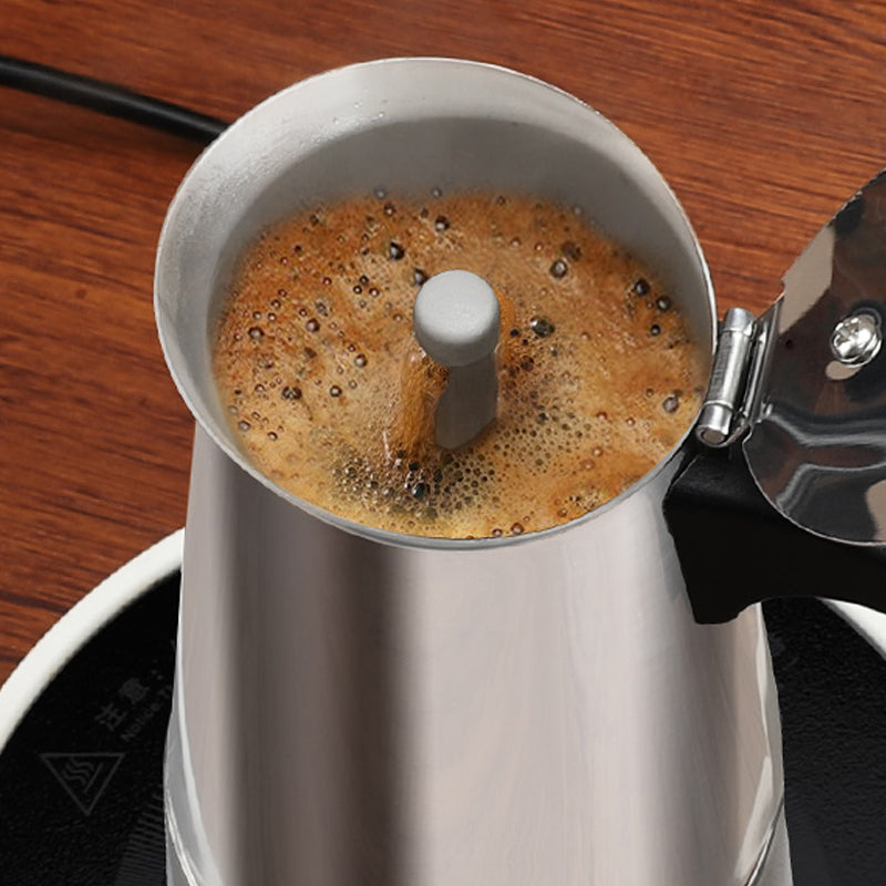 Top view into the open moka pot as coffee rises through the central spout