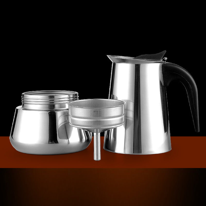 The moka pot taken apart: lower chamber, filter funnel and upper jug on a dark surface