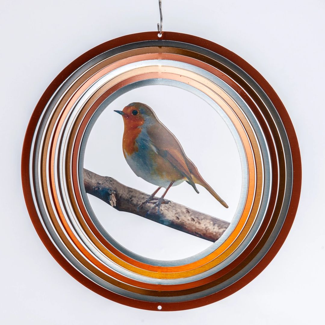 Flat stainless steel wind spinner with copper, orange and silver rings around a printed robin on a branch