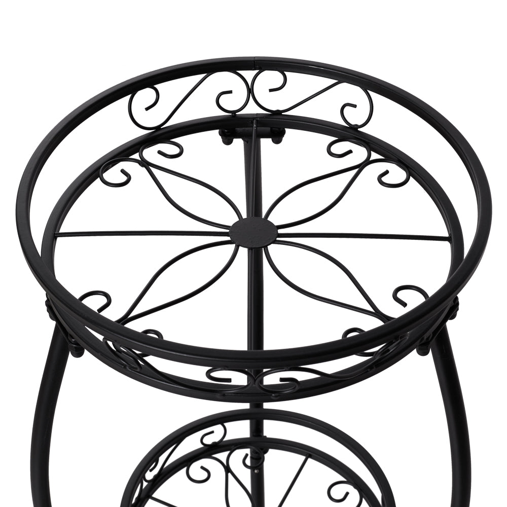 Close-up of the top tier's scrollwork and leaf-pattern base in black iron
