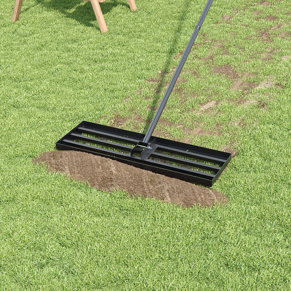The open bar head smoothing a patch of bare brown soil into a mown green lawn, with wooden trestle legs at the top of the frame.