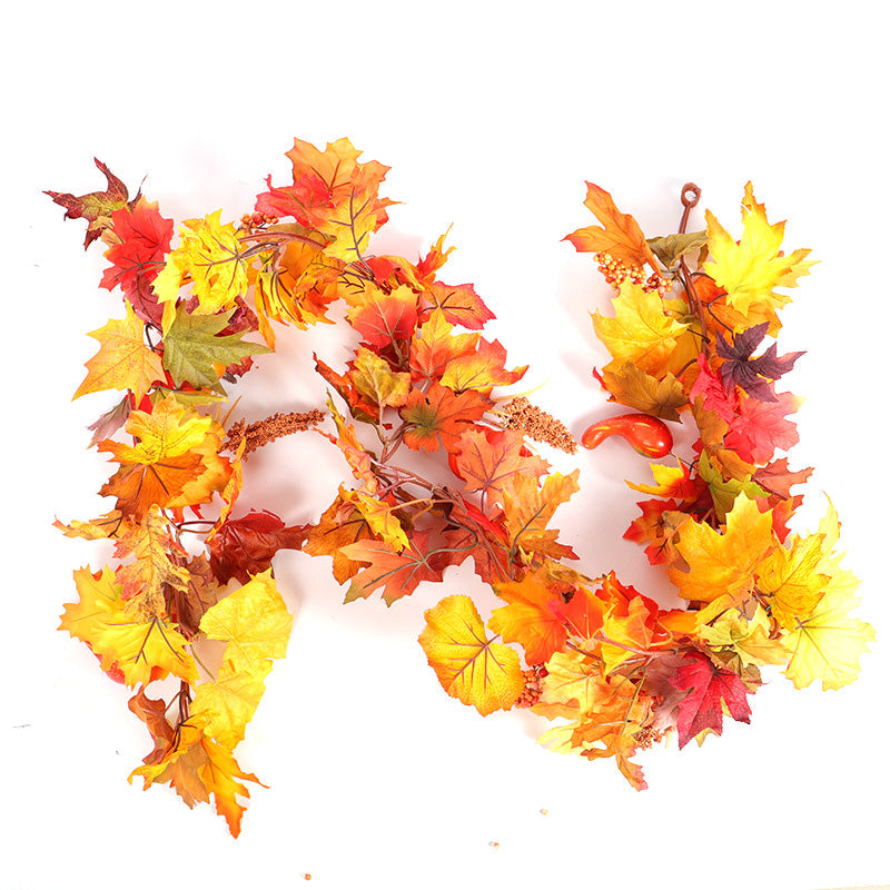 Close view of the garland's orange, red and yellow maple leaves with berry picks on white