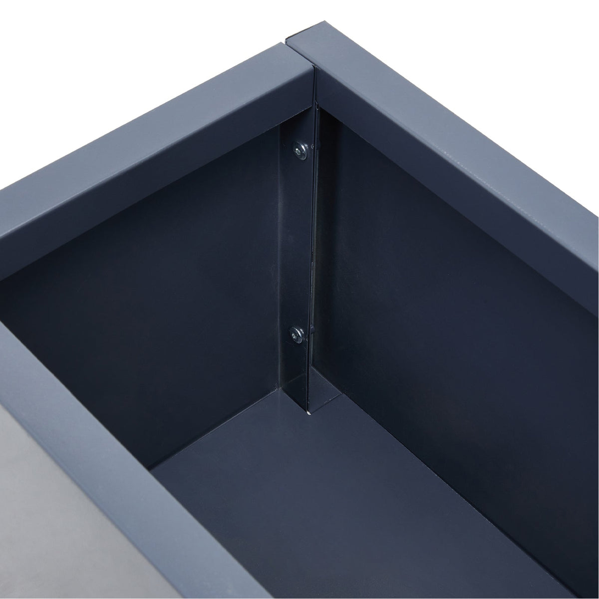 Inside corner of the grey steel planter showing its folded seam