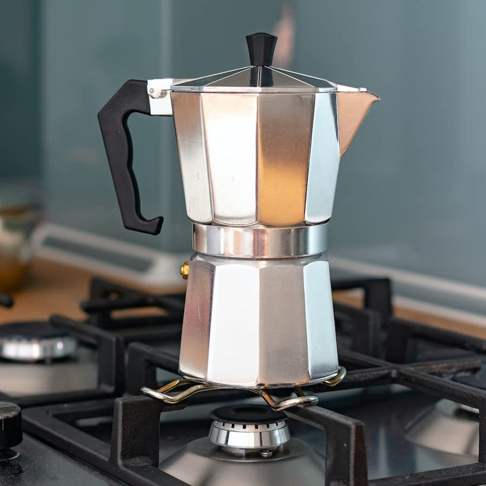 Aluminium moka pot standing on a pan support over a gas burner