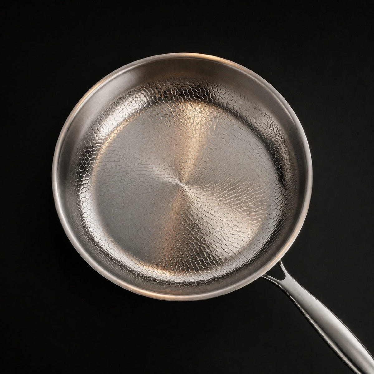 Overhead view of the empty pan, the honeycomb hammer pattern covering the base and curving up the sloped walls.