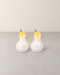 Two white ceramic duck salt and pepper shakers with yellow flower hats and orange beaks