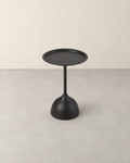 Round black metal side table with a raised rim on a slim stem and tulip base