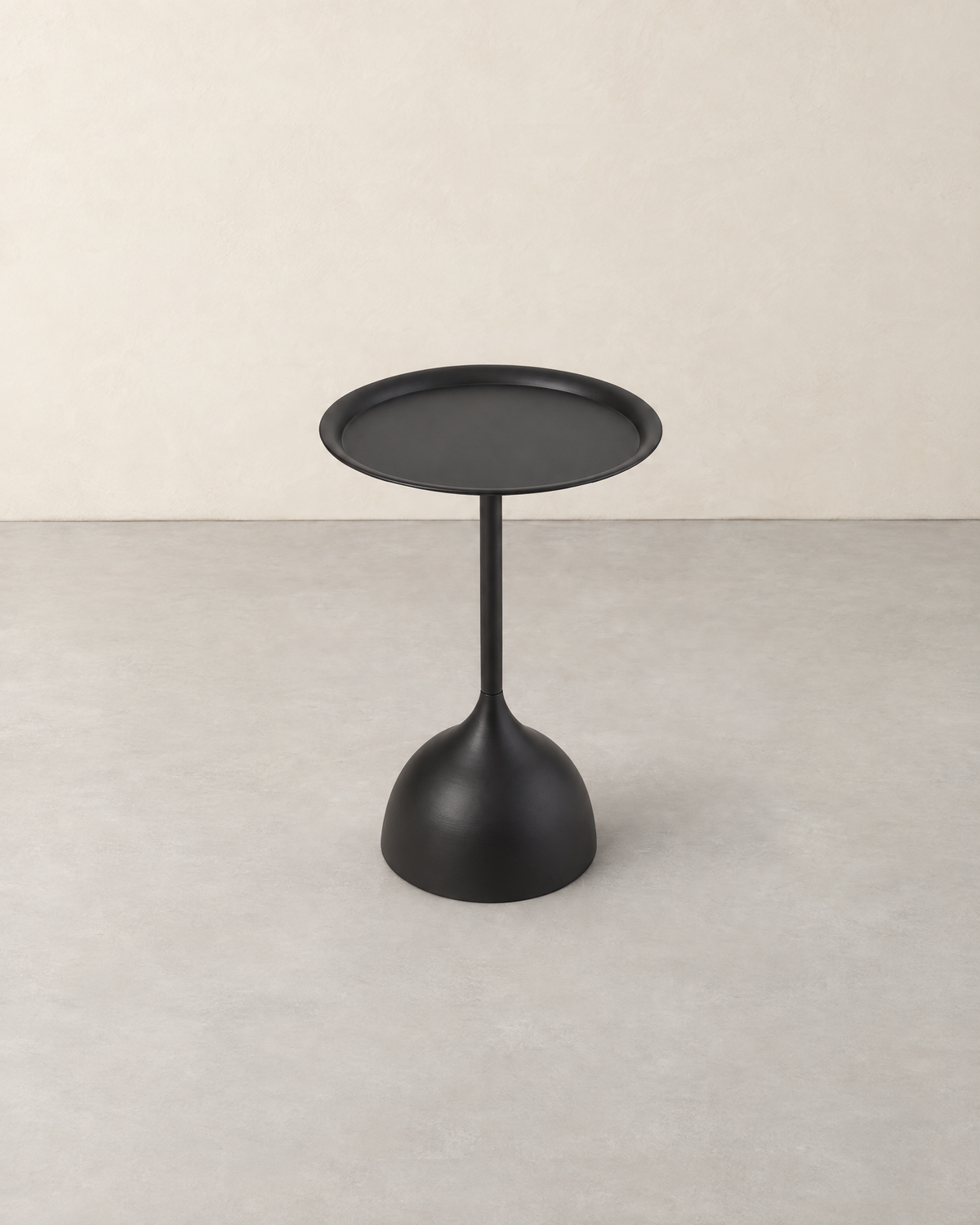 Round black metal side table with a raised rim on a slim stem and tulip base