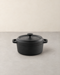 Round black cast iron Dutch oven with lid and two loop handles
