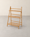 Folding natural wood ladder plant stand with three slatted shelves, empty