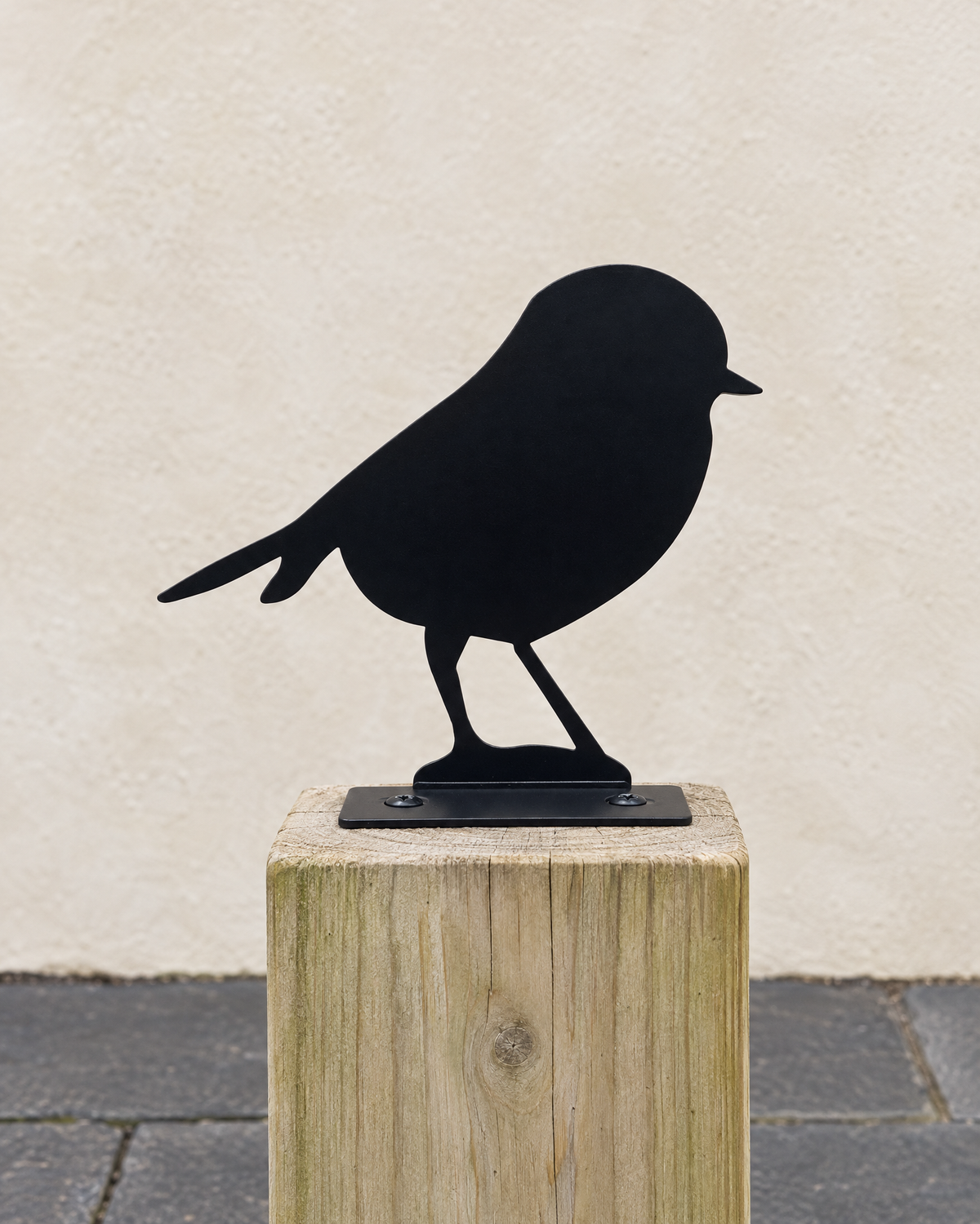 Black steel robin fence topper screwed to the top of a wooden fence post