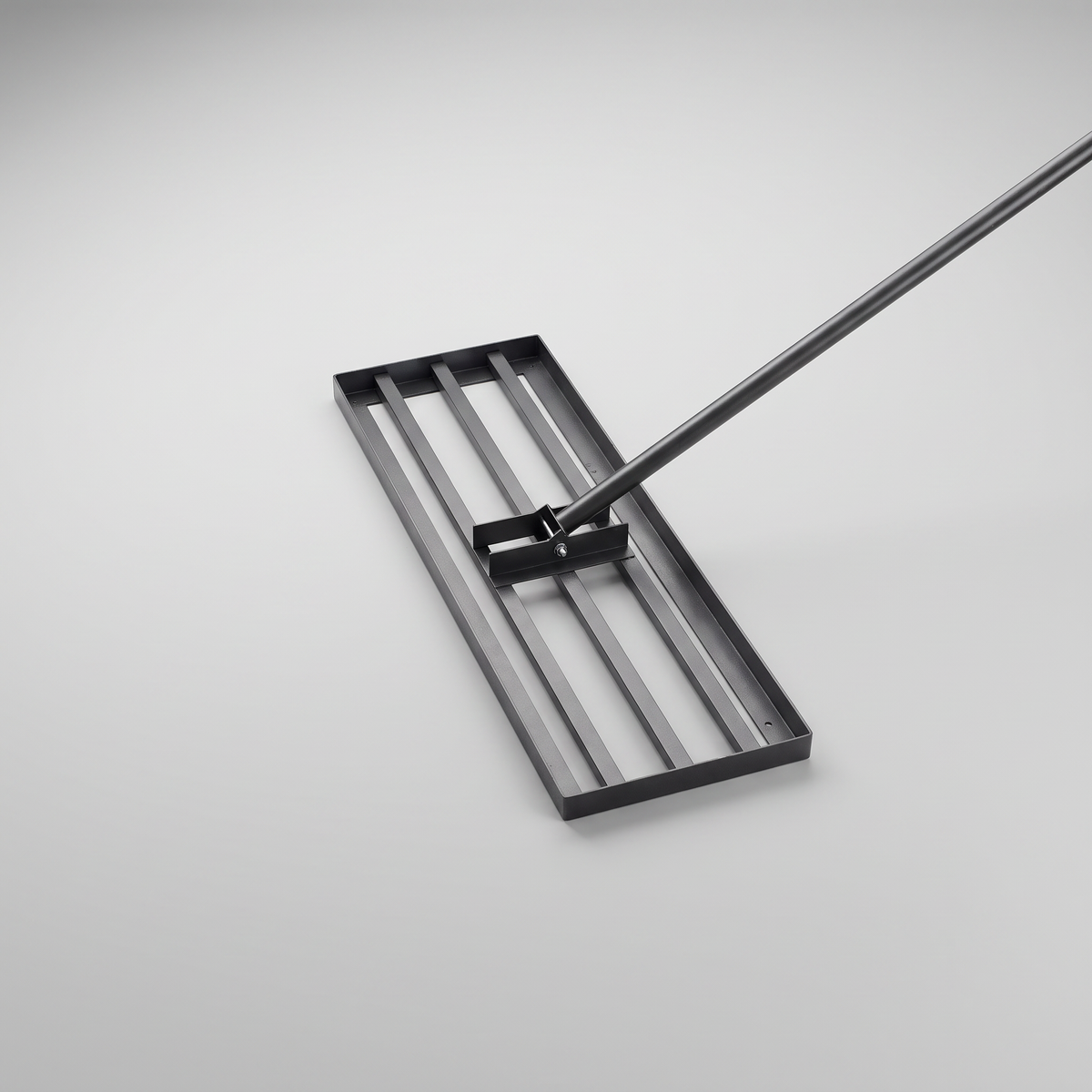 Lawn levelling rake with a black steel grid head and a long silver stainless steel handle on a grey background